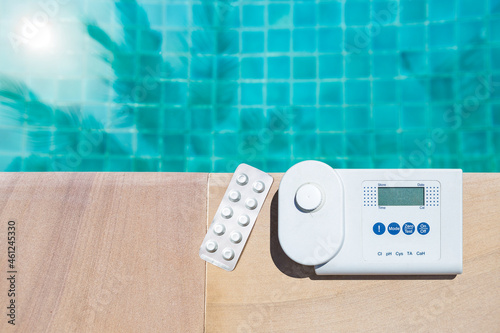 Foto Digital water tester equipment and pool tester tablet on swimming pool edge with