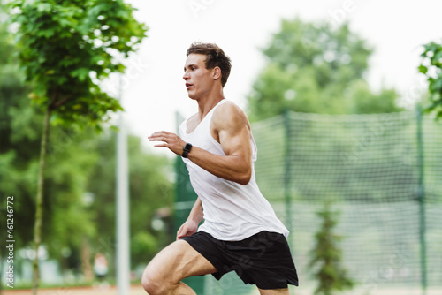 Young white sportsman running while working out on playground