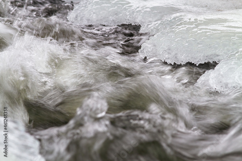 fast river flow at the icy shore