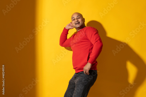 Portrait of a bald man dancing against plain background. © IndiaPix