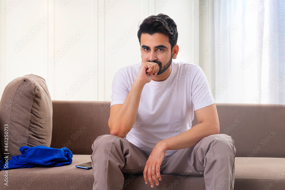PORTRAIT OF A MAN SITTING ALONE AND THINKING AT HOME