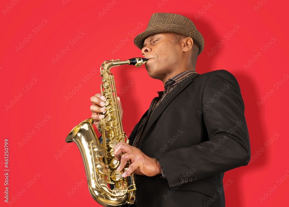 Fototapeta premium Beautiful golden saxophone on red background,