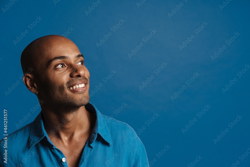 Black bold man wearing shirt smiling and looking aside Black bold man wearing shirt smiling and looking aside