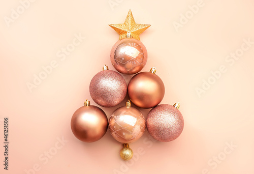 Creative Merry Christmas and Happy New Year pink background with tree made from Christmas balls and star  banner top view