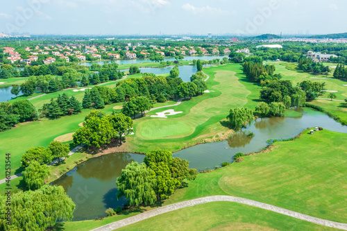 Aerial view of green lawn and forest on golf course.Green golf course scenery. © ABCDstock
