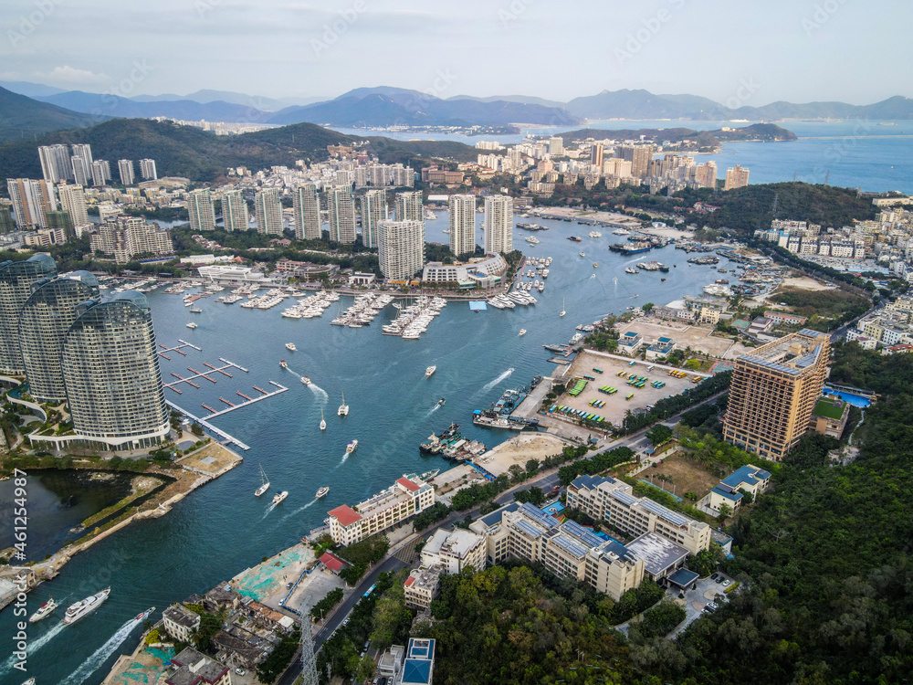Aerial drone shot cityscape of Sanya city with marina and buildings Hainan tropical island China