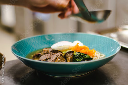 Beef ramen soup with poached egg and vegetables at a restaurant