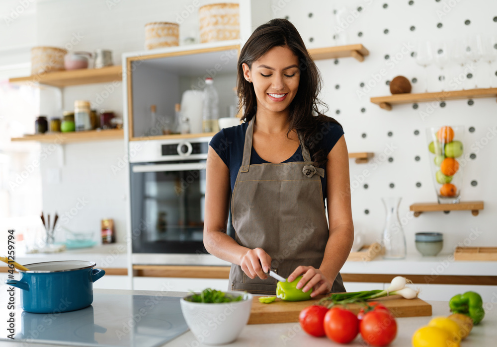 Happy woman making healthy food in kitchen. Happy woman making healthy food in kitchen.