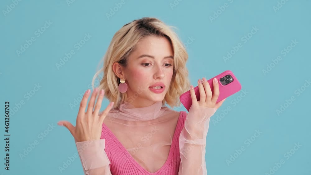 Close-up view of emotionally woman recording a voice message on the phone in blue studio