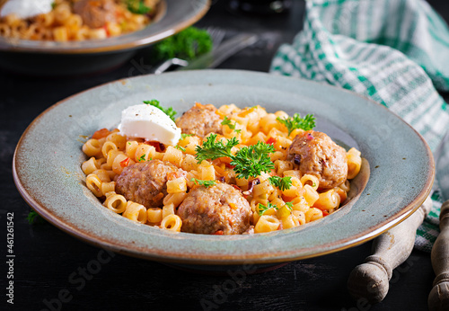 Italian traditional ditalini pasta with meatballs in tomato sauce and vegetables in bowl. Ditalini pasta and beef balls with marinara tomato sauce.