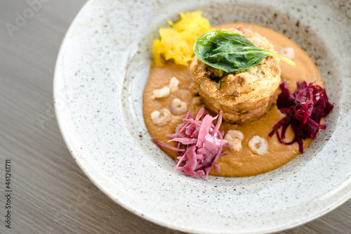 Pike cutlet with pumpkin sauce and fermented cabbage in different colors at a restaurant