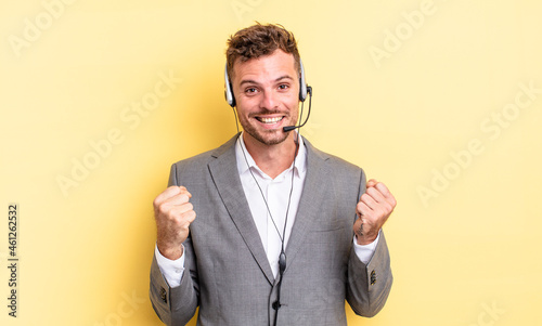 young handsome man feeling shocked,laughing and celebrating success. telemarketer concetp photo