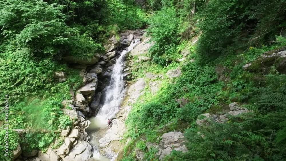 A mountain river forms a waterfall in the forest. Hike along the ecological trail in the mountains. Travel to Russia, Sochi. Green trees. A stream of clean water among rocks. High quality FullHD A mountain river forms a waterfall in the forest. Hike along the ecological trail in the mountains. Travel to Russia, Sochi. Green trees. A stream of clean water among rocks. High quality FullHD