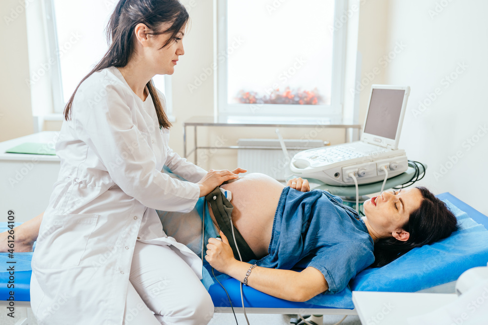 Obraz premium Gynecologist checking fetal heartbeat of pregnant woman