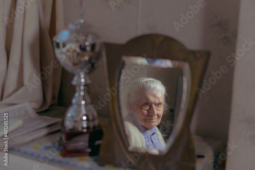 Grandmother. An old grandmother looks in the mirror.