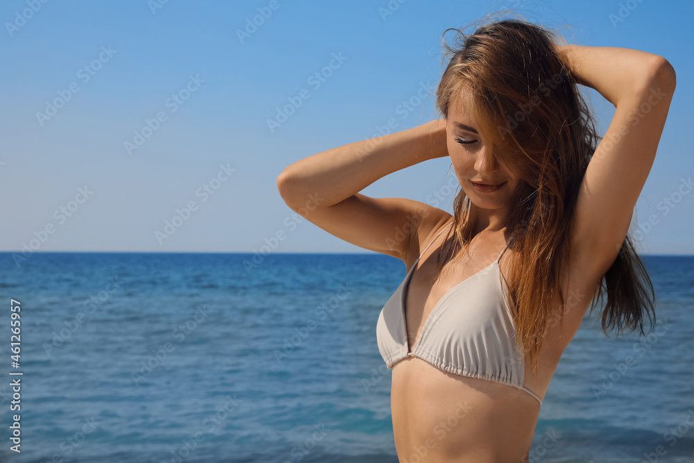 Attractive woman in bikini near sea on sunny day Attractive woman in bikini near sea on sunny day