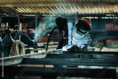 Industrial welder welding fabricated construction in factory, Welding process by Flux Core Welding, FCAW