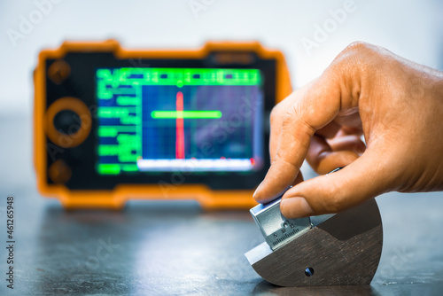 Angle ultrasonic probe or shear wave ultrasonic probe on calibration block in factory. UT calibration.