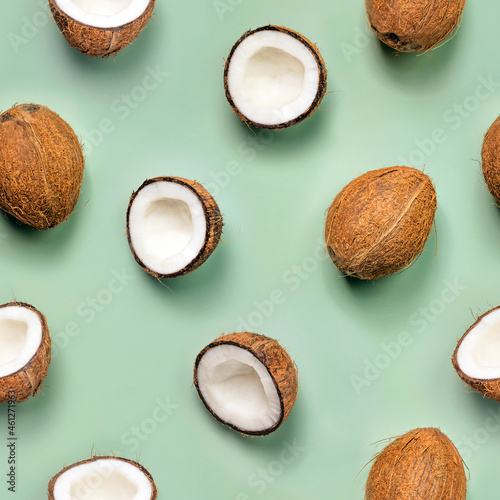 Coconut seamless pattern on green background. Half and whole coconuts. Top view