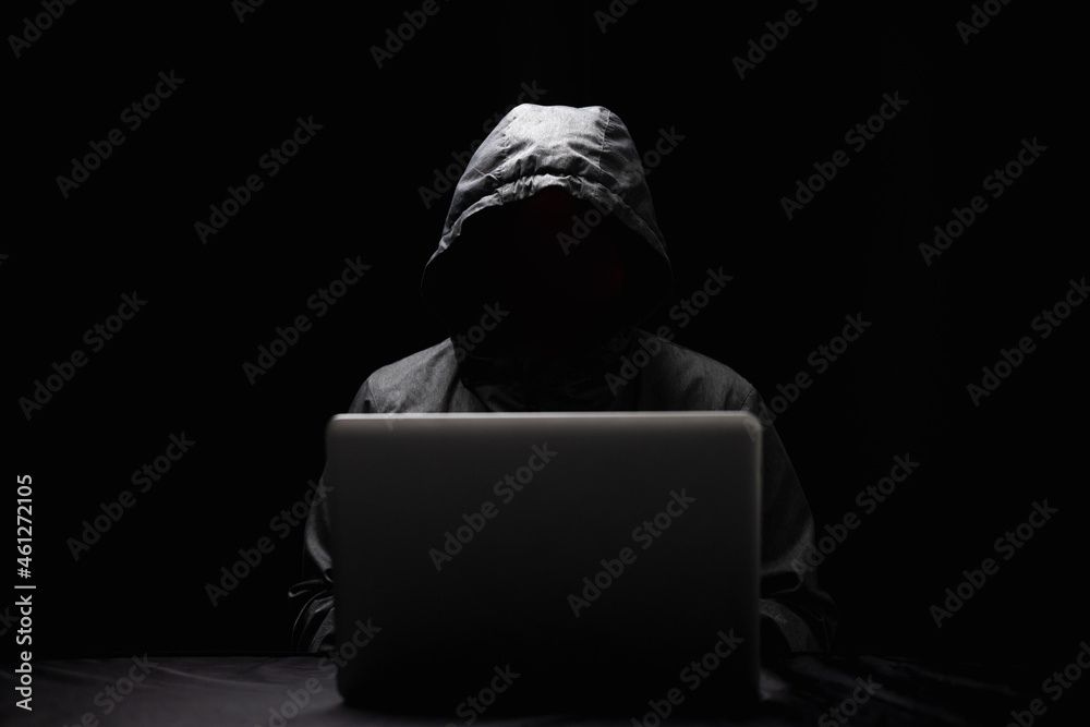 Hackers wear hoods to cover their faces. Hacking to steal important information. Use a computer to release malware viruses Ransom and harass organizations. He sitting in the dark room with neon light