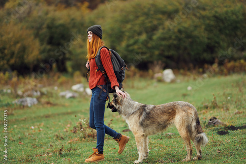 woman hiker with a backpack in nature with a dog © SHOTPRIME STUDIO