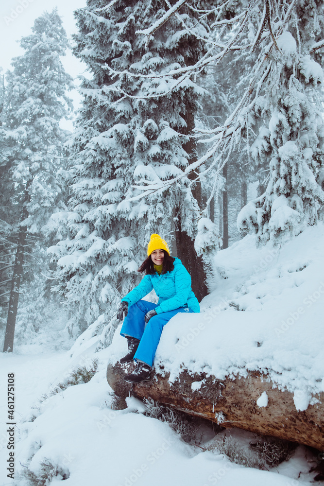 woman hiker enjoying the view of snowed winter forest
