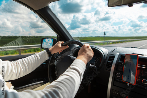 man hands on steering wheel cloudy sunny day