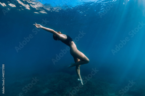 Woman freediver posing underwater in ocean. Free diving and beautiful lady
