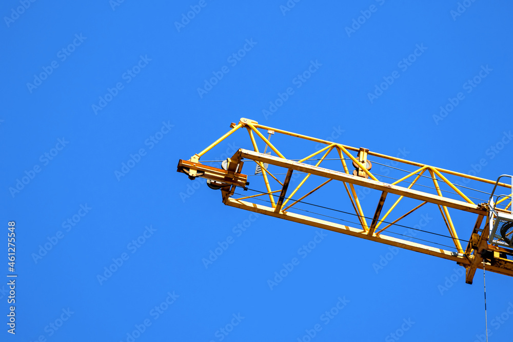 Yellow construction crane operating, blue sky background photo Yellow construction crane operating, blue sky background photo
