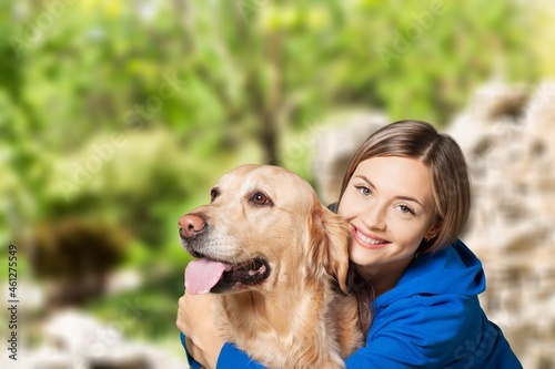 Portrait of beautiful girl petting and hugging dog outdoors. © BillionPhotos.com