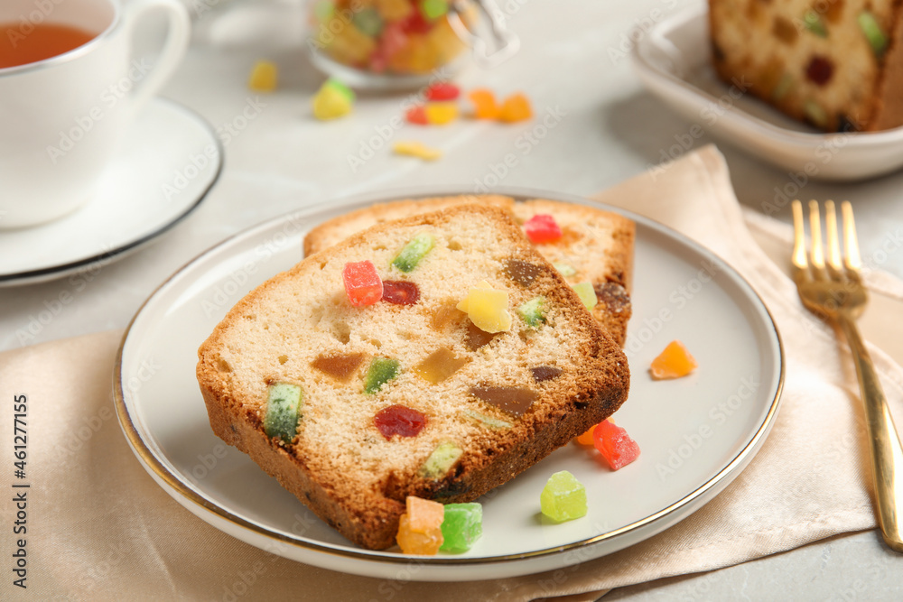 Delicious cake with candied fruits and tea on light table Delicious cake with candied fruits and tea on light table