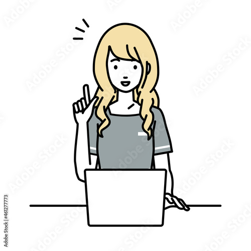 デスクで座ってPCを開いて何かひらめいたエステ店員の女性