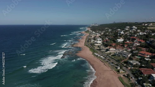 Aerial view moving over beach with houses alongside in beachside town photo