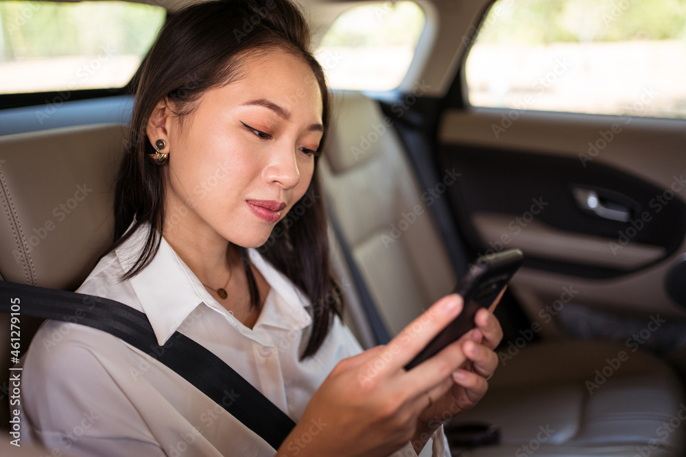Ethnic woman using smartphone during taxi ride Ethnic woman using smartphone during taxi ride