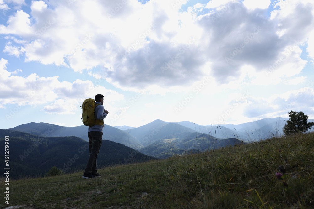 Tourist with backpack enjoying mountain landscape, space for text