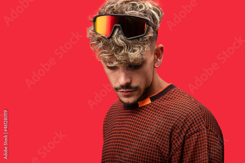 Stylish man with curly hair in bright studio photo