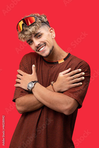 Stylish man with curly hair in bright studio photo
