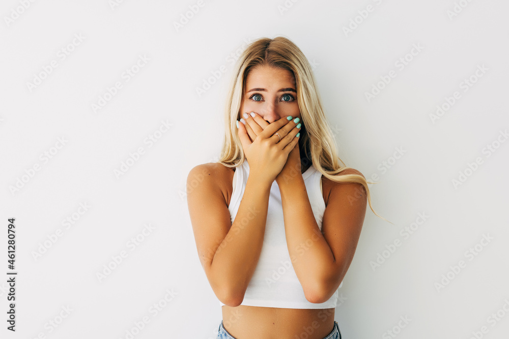 Shocked woman covers her opened mouth with hand, isolated on white Shocked woman covers her opened mouth with hand, isolated on white