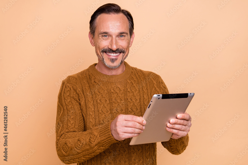 Photo of ceo brunet man write tablet wear knitwear sweater isolated on beige color background Photo of ceo brunet man write tablet wear knitwear sweater isolated on beige color background