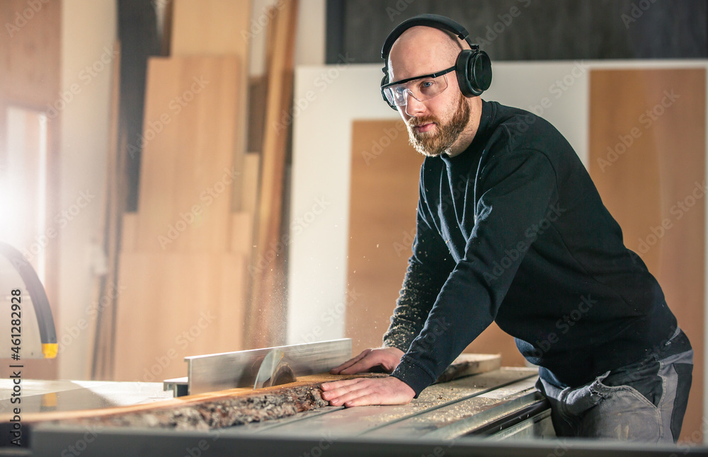 Carpenter working on a woodworking saw machines in carpentry shop, industrial concept Carpenter working on a woodworking saw machines in carpentry shop, industrial concept