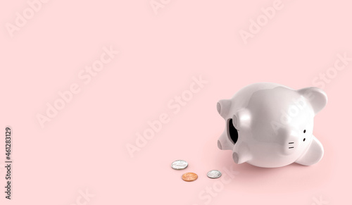fallen piggy bank with US coins coming out, white piggy with pink background bottom right corner