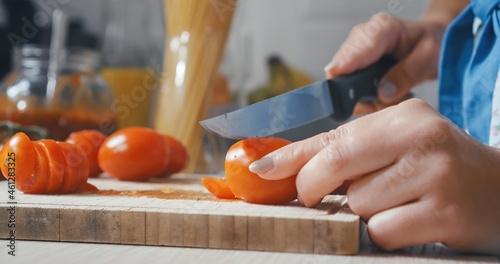 Close up of woman hands cutting tomatos for pasta sauce