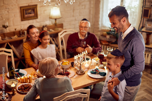 Happy Jewish extended family enjoys in lunch at dining table on Hanukkah.
