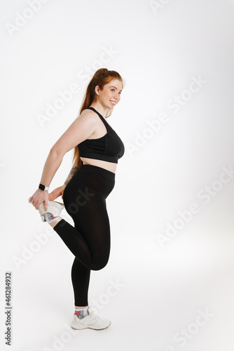 Smiling young plus size fitness woman in sportswear