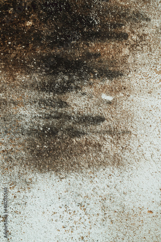 Tekstura zniszczonej brudnej ściany, ciemne plamy na popękanym murze.