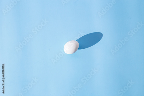 Raw white egg on blue background