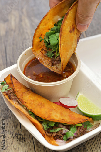 birria tacos with broth for dipping, mexican food photo