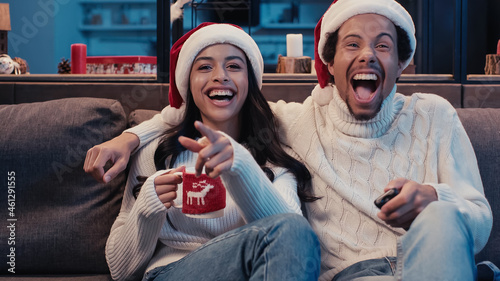 Εκτύπωση καμβά cheerful african american couple watching comedy movie on christmas