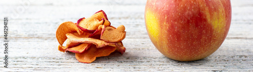 banner of A pile of dried slices of apples and fresh ripe apples on wooden background.