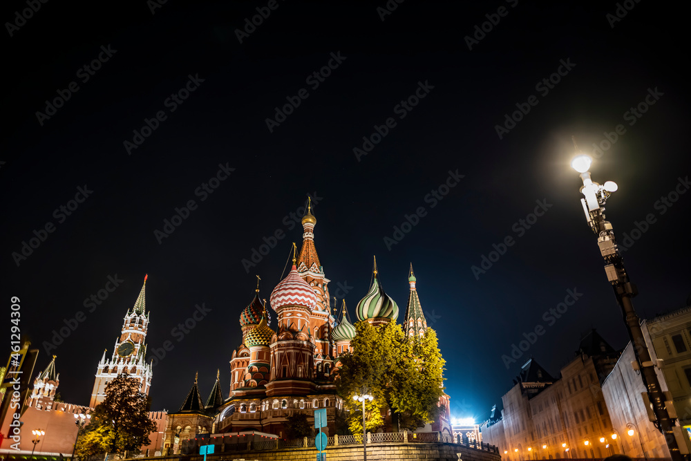 night landscape of the city with illuminated old houses, churches and a fortress wall 